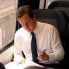 British Prime Minister David Cameron works as he travels by train from Washington DC to New York City